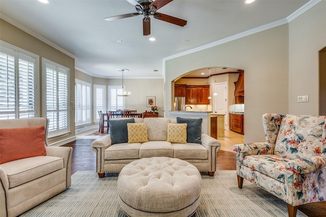 living room with ceiling fan, light hardwood / wood-style floors, and crown molding