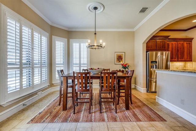 tiled dining space featuring a notable chandelier and crown molding