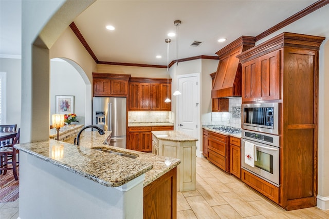 kitchen with sink, stainless steel appliances, tasteful backsplash, pendant lighting, and a kitchen island