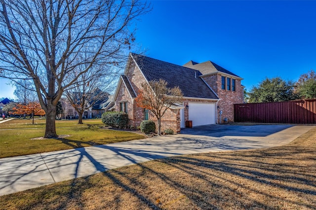 view of side of property featuring a lawn and a garage