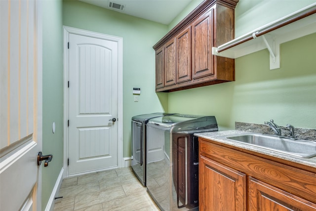 washroom featuring washer and clothes dryer, cabinets, and sink