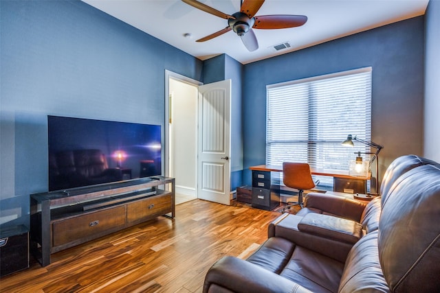 living room featuring hardwood / wood-style floors and ceiling fan