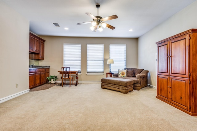 sitting room featuring light carpet and ceiling fan