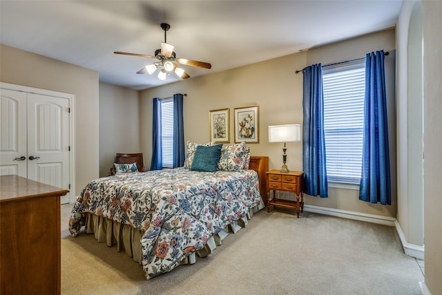 carpeted bedroom featuring ceiling fan and a closet