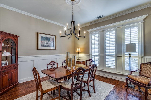 dining room with crown molding, a chandelier, and dark hardwood / wood-style floors