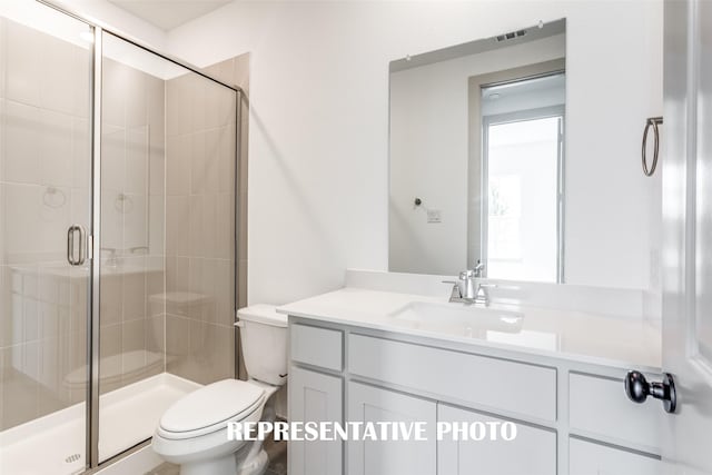 bathroom featuring vanity, an enclosed shower, and toilet