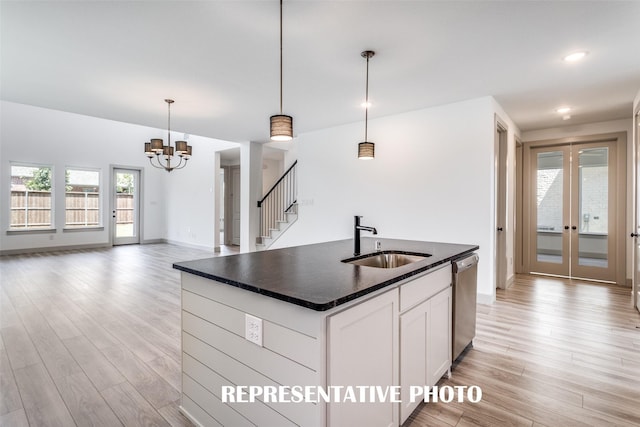 kitchen with sink, decorative light fixtures, dishwasher, a kitchen island with sink, and white cabinets