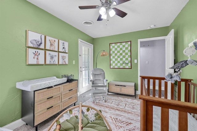 bedroom featuring ceiling fan, carpet floors, a nursery area, and french doors