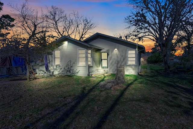 property exterior at dusk with a lawn