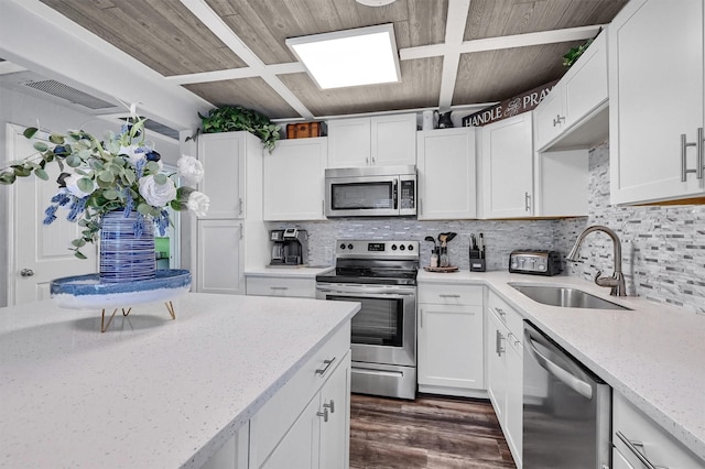 kitchen featuring light stone countertops, tasteful backsplash, stainless steel appliances, sink, and white cabinets