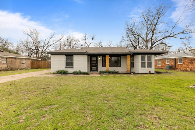 single story home with central AC unit and a front yard