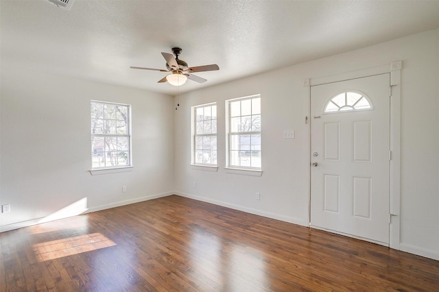 foyer with dark wood-type flooring, ceiling fan, and a textured ceiling