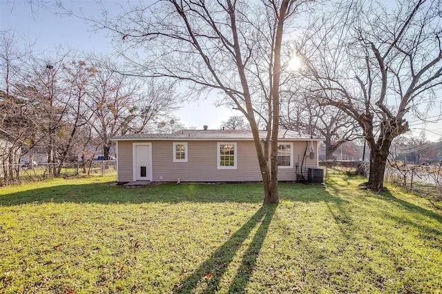 back of house featuring central AC and a lawn