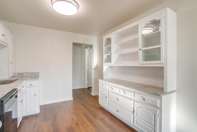 kitchen with dark wood-type flooring, white cabinets, sink, black dishwasher, and light stone counters