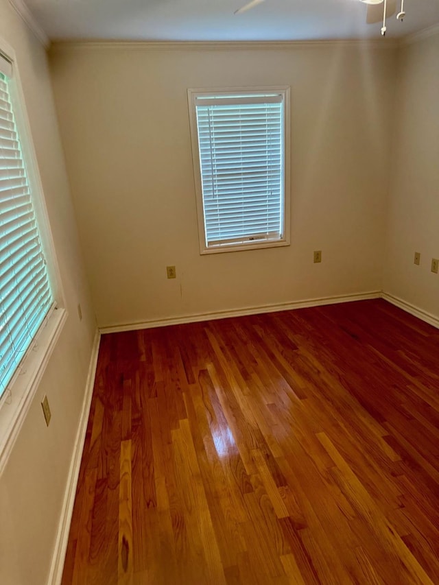 spare room featuring crown molding, plenty of natural light, and hardwood / wood-style flooring