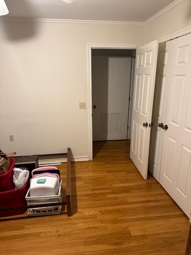 hall featuring light hardwood / wood-style flooring and crown molding