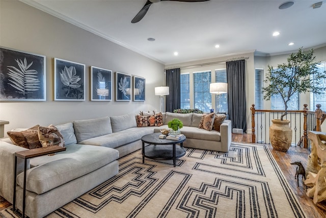 living room with ornamental molding, ceiling fan, and light wood-type flooring