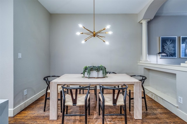 dining area with decorative columns, dark wood-type flooring, and a chandelier