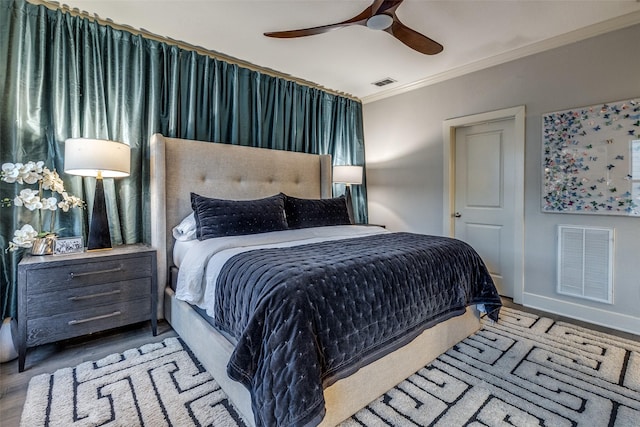 bedroom with ceiling fan, crown molding, and light wood-type flooring