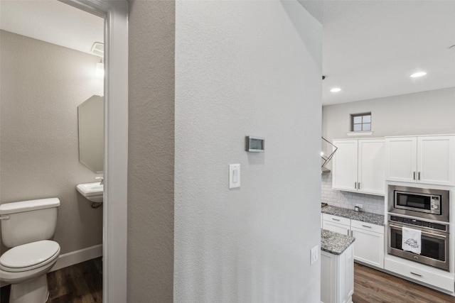 bathroom with backsplash, hardwood / wood-style flooring, and toilet