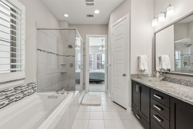 bathroom featuring tile patterned flooring, shower with separate bathtub, and vanity