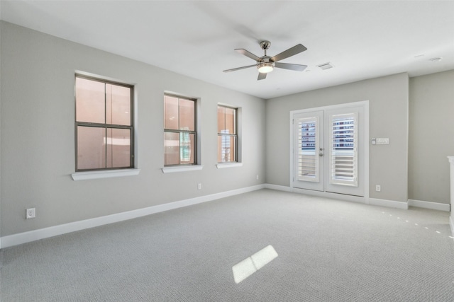 carpeted empty room with ceiling fan and french doors