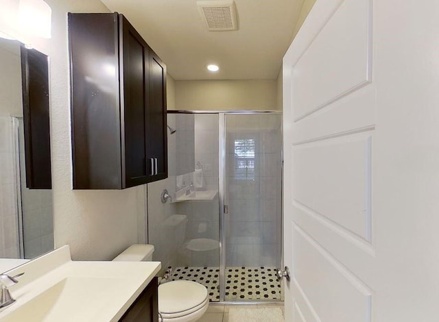 bathroom with tile patterned floors, vanity, toilet, and walk in shower