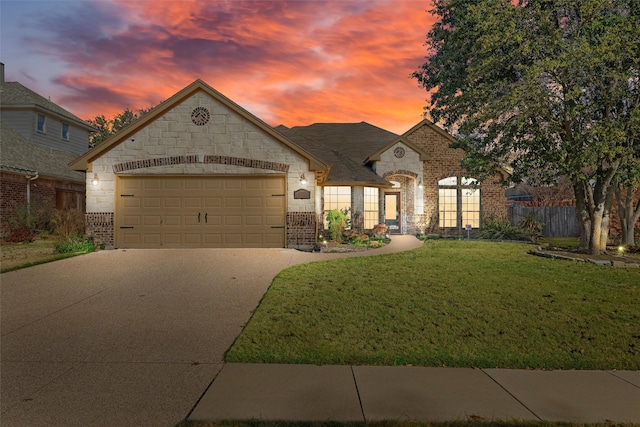 french country style house featuring a yard and a garage