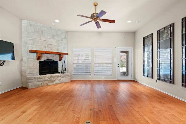 unfurnished living room featuring a fireplace, light hardwood / wood-style flooring, and ceiling fan