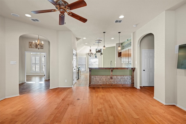 interior space featuring ceiling fan, sink, light hardwood / wood-style floors, and decorative light fixtures