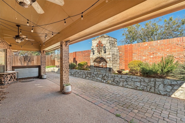 view of patio / terrace with an outdoor stone fireplace and ceiling fan