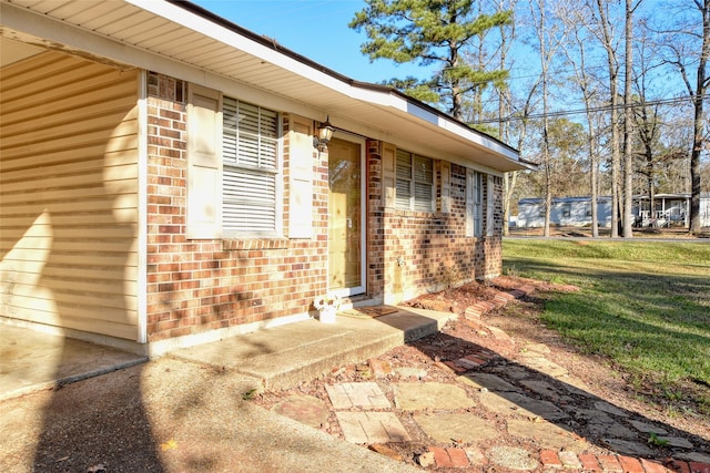 view of exterior entry with a yard