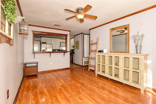 unfurnished living room with ceiling fan, light hardwood / wood-style floors, and crown molding