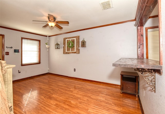 unfurnished living room with ceiling fan, ornamental molding, and light hardwood / wood-style flooring