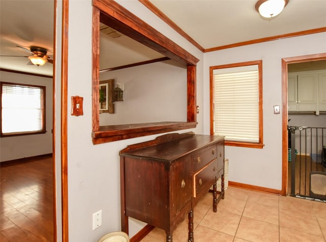 hall with light tile patterned flooring and crown molding