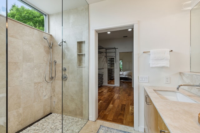 bathroom with a tile shower, vanity, and tile patterned floors