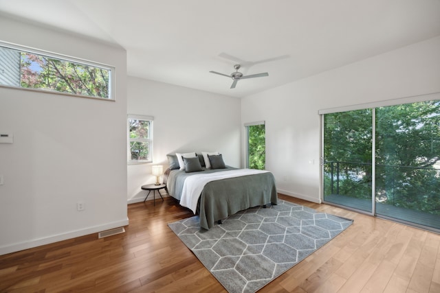 bedroom with hardwood / wood-style floors, access to outside, and ceiling fan