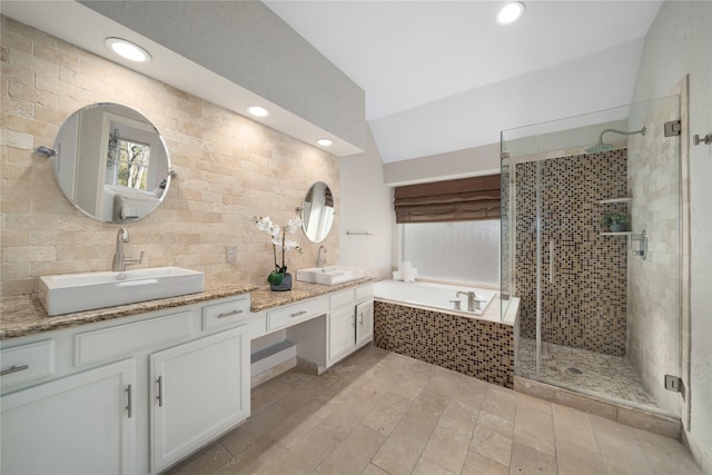 bathroom with vanity, vaulted ceiling, and independent shower and bath