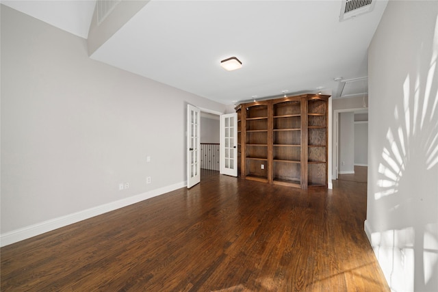 spare room featuring french doors and dark wood-type flooring