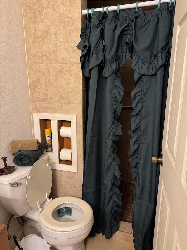 bathroom featuring walk in shower, tile patterned flooring, and toilet