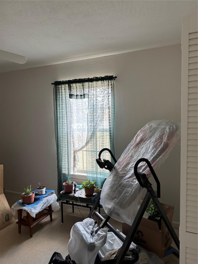 miscellaneous room with a textured ceiling and light tile patterned flooring