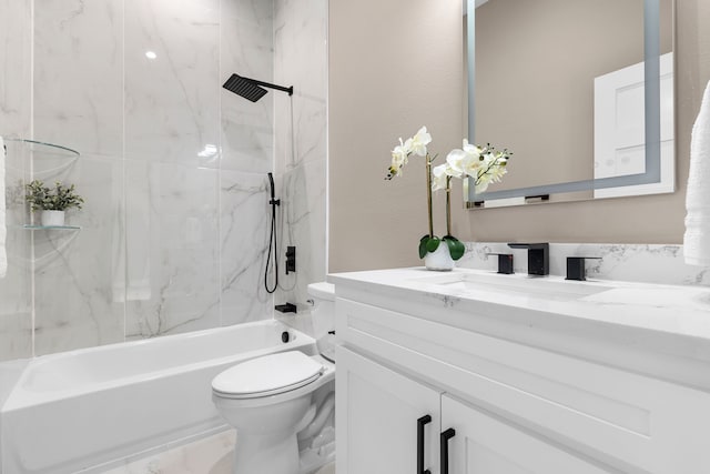 full bathroom featuring tiled shower / bath combo, toilet, and vanity