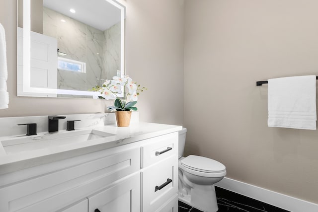 bathroom with vanity, toilet, and a shower