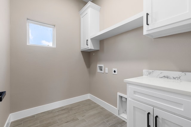 clothes washing area featuring cabinets, washer hookup, light hardwood / wood-style floors, and electric dryer hookup