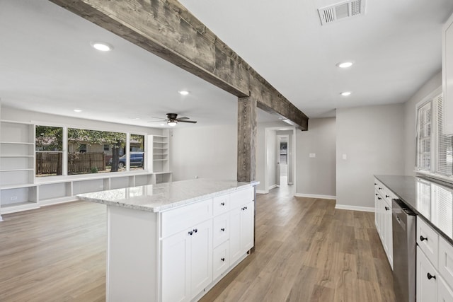 kitchen with light stone counters, ceiling fan, dishwasher, a center island, and white cabinetry