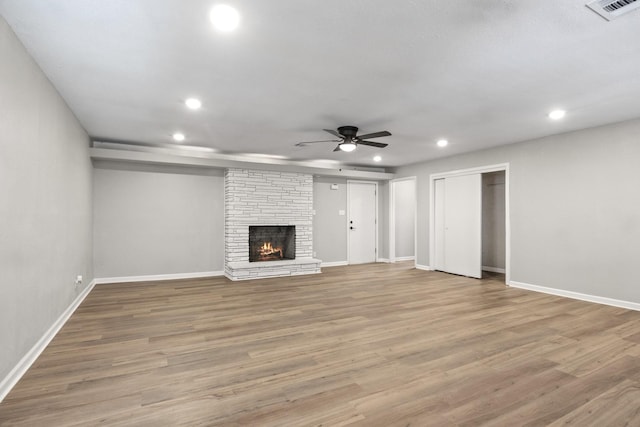 unfurnished living room with a fireplace, light hardwood / wood-style flooring, and ceiling fan