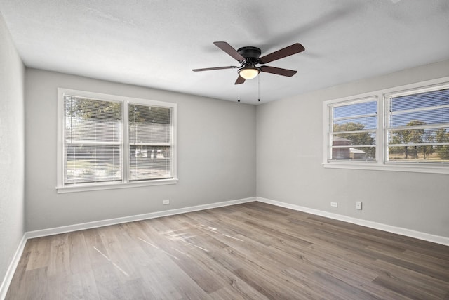 empty room with ceiling fan and wood-type flooring