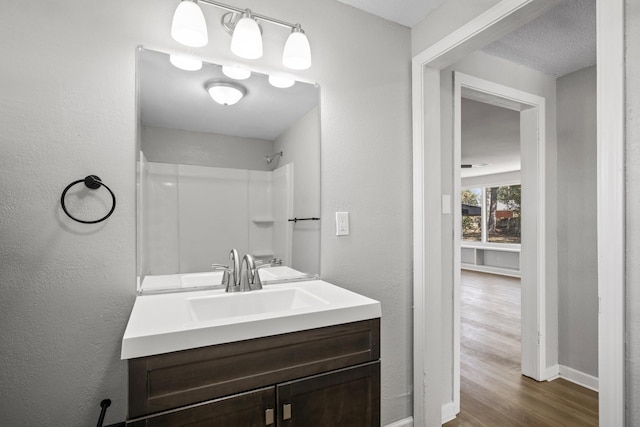 bathroom with vanity, a textured ceiling, and hardwood / wood-style flooring