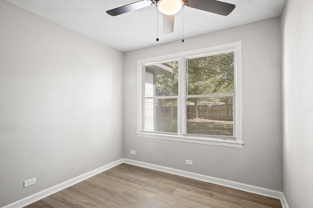 empty room with hardwood / wood-style floors and ceiling fan