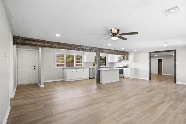 kitchen with stainless steel appliances, white cabinetry, and light hardwood / wood-style flooring